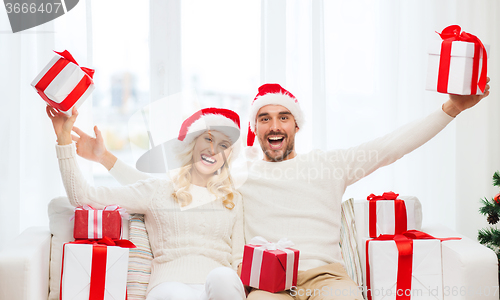 Image of happy couple at home with christmas gift boxes