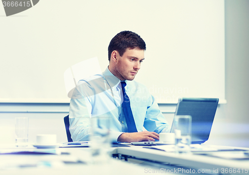 Image of businessman with laptop working in office