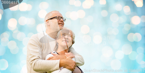 Image of happy senior couple over blue holidays lights