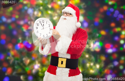 Image of man in costume of santa claus with clock