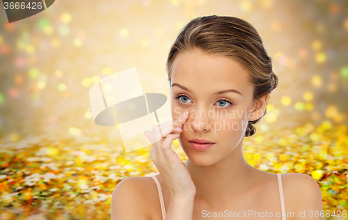 Image of young woman applying cream to her face