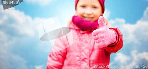 Image of happy girl showing thumbs up over blue sky
