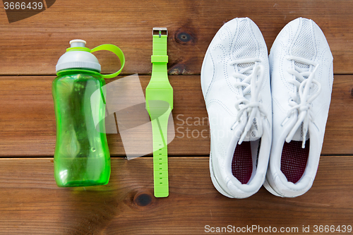 Image of close up of sneakers, bracelet and water bottle