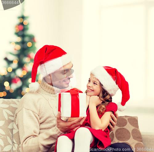 Image of smiling father giving daughter gift box