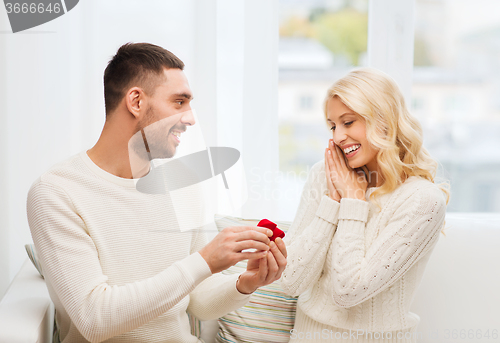 Image of man giving woman engagement ring for christmas