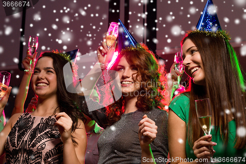 Image of smiling friends with glasses of champagne in club