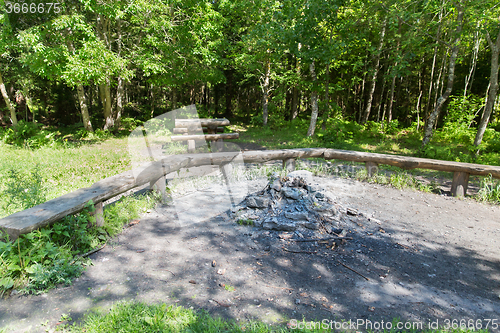 Image of camp fire place with bench seats in forest