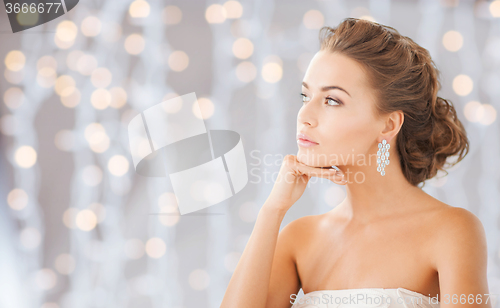 Image of beautiful woman wearing shiny diamond earrings