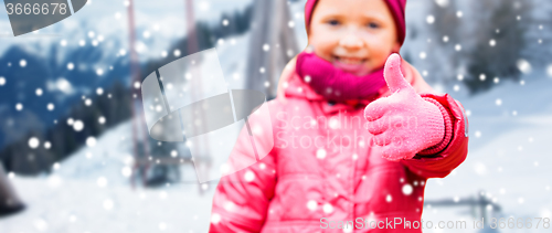 Image of happy girl showing thumbs up over winter