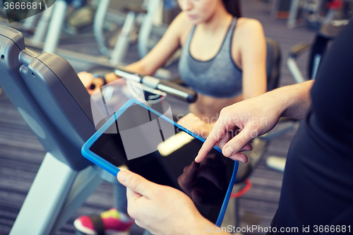 Image of close up of trainer hands with tablet pc in gym