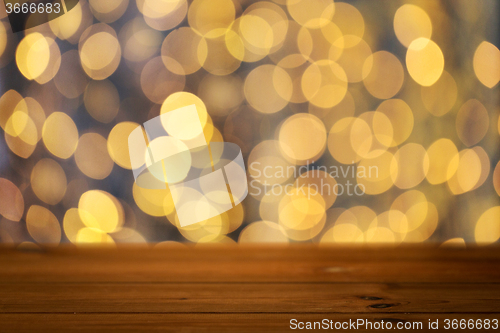 Image of empty wooden table with christmas golden lights