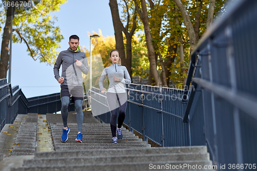 Image of couple running downstairs in city