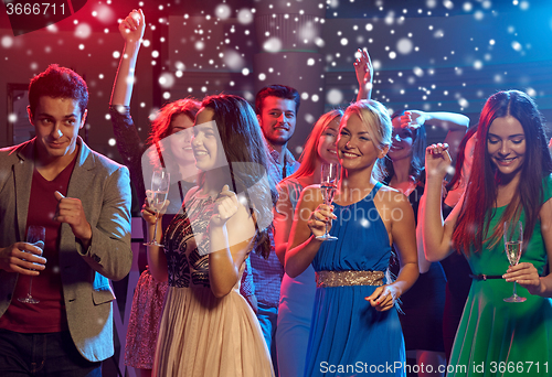 Image of smiling friends with wine glasses and beer in club