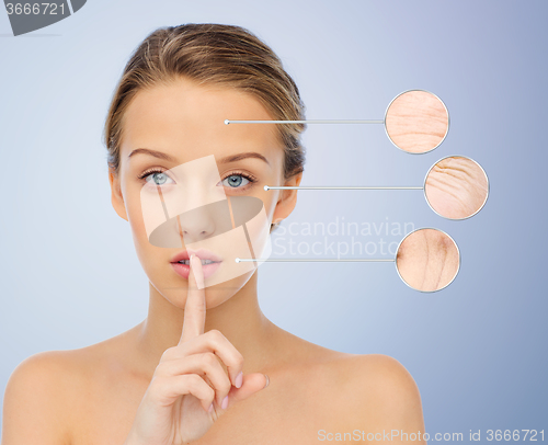 Image of beautiful young woman holding finger on lips