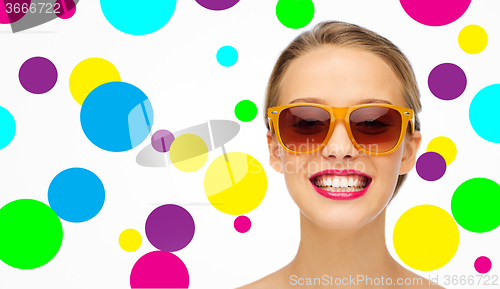 Image of happy young woman in sunglasses with pink lipstick