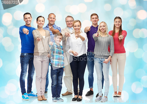 Image of group of smiling people pointing finger on you