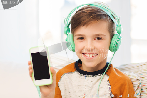 Image of happy boy with smartphone and headphones at home
