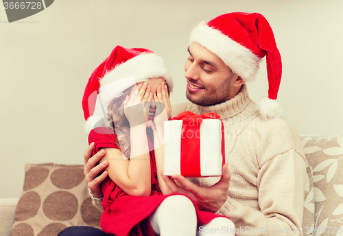 Image of smiling daughter waiting for a present from father