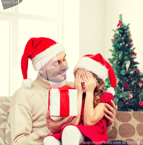 Image of smiling daughter waiting for present from father