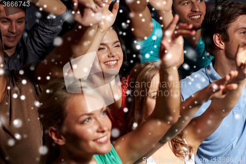 Image of smiling friends at concert in club