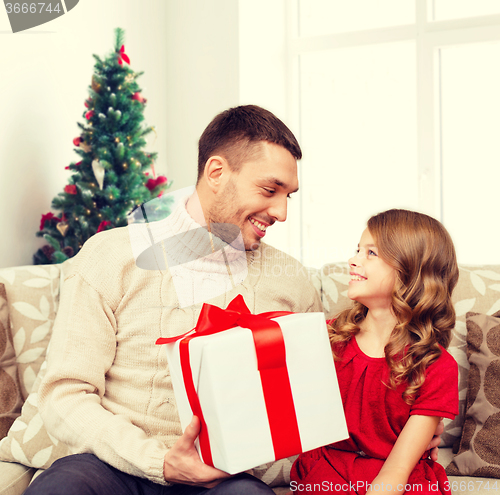 Image of smiling father and daughter with gift box