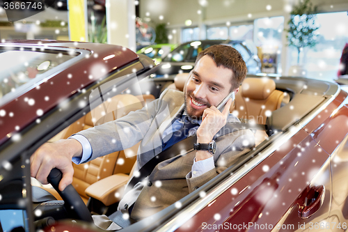 Image of man calling on smartphone at show or car salon