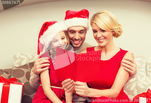 Image of smiling family reading postcard