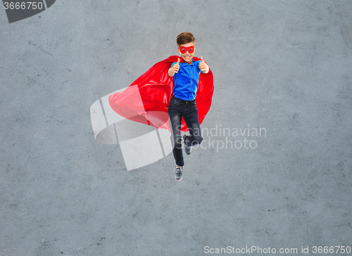 Image of boy in super hero cape and mask showing thumbs up