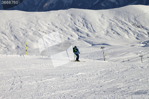 Image of Skier on slope in sun evening