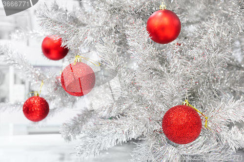 Image of Red baubles on silver artificial christmas tree