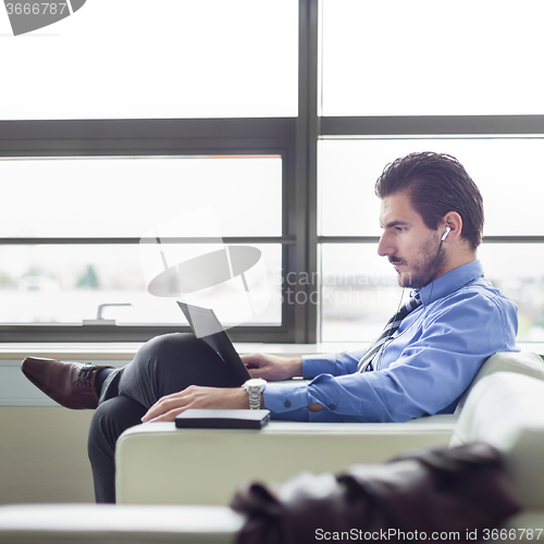 Image of Businessman in office working on laptop computer.