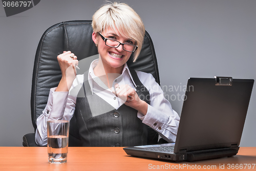 Image of Angry businesswoman working with laptop in office