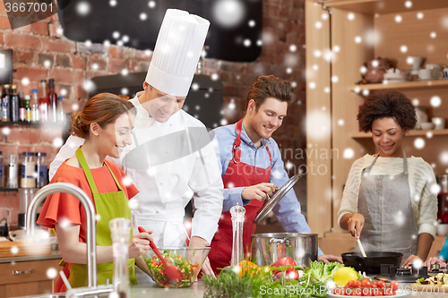 Image of happy friends and chef cook cooking in kitchen