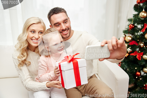 Image of family taking selfie with smartphone at christmas