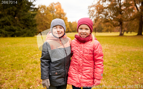 Image of happy little girl and boy in autumn park