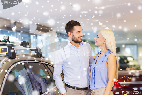 Image of happy couple buying car in auto show or salon