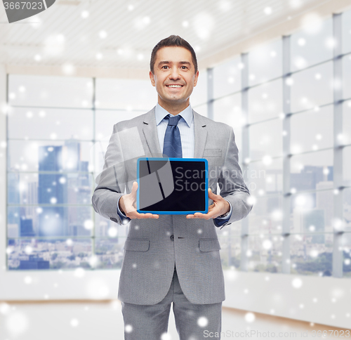 Image of happy businessman in suit showing tablet pc screen