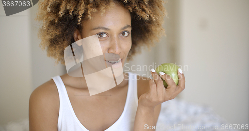 Image of Woman Sitting On Bed And Eating Apple