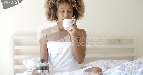 Image of Attractive Woman With A Cup Of Coffee On The Bed