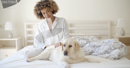 Image of Woman And Her Dog Resting In Bed
