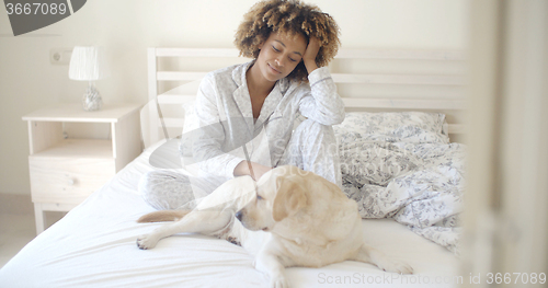 Image of Woman And Her Dog Resting In Bed