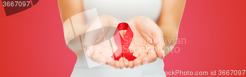 Image of close up of hands with red AIDS awareness ribbon