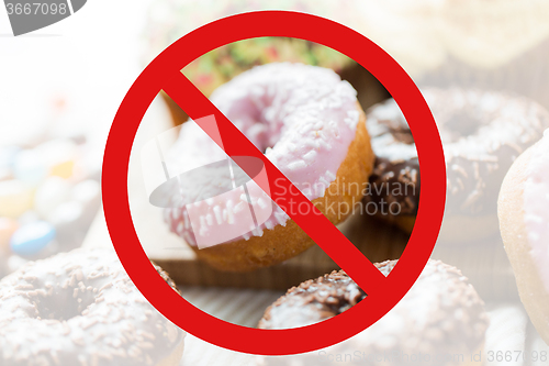 Image of close up of glazed donuts pile behind no symbol