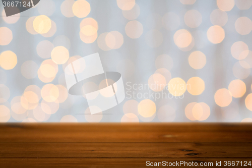 Image of empty wooden table with christmas golden lights