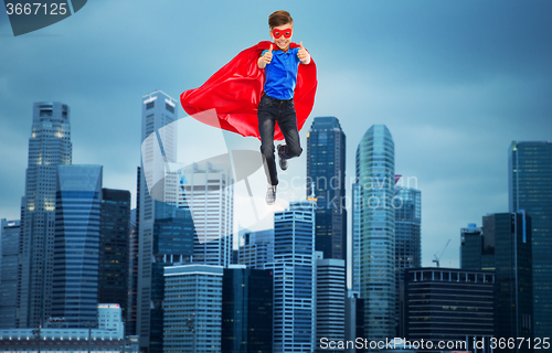 Image of boy in super hero cape and mask showing thumbs up