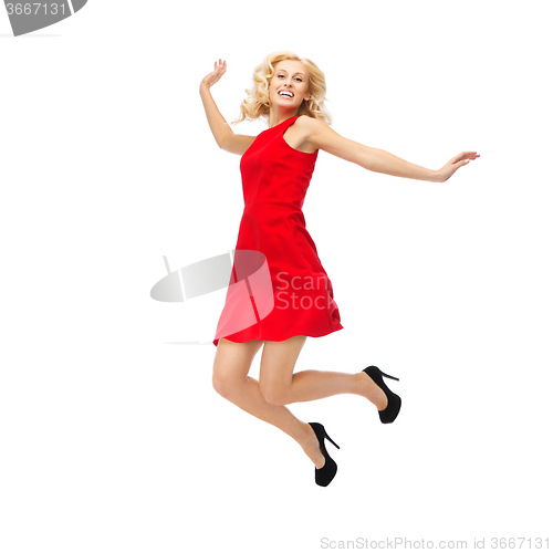 Image of happy young woman in red dress jumping high