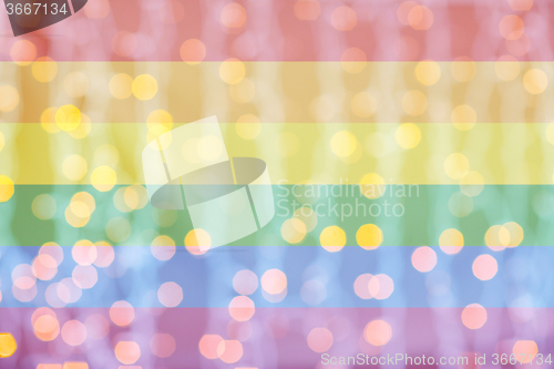 Image of blurred golden lights over rainbow flag background