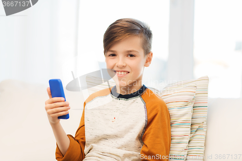 Image of boy with smartphone texting or playing at home