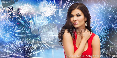 Image of beautiful woman in red over firework at night city