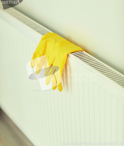 Image of close up of rubber gloves hanging on heater